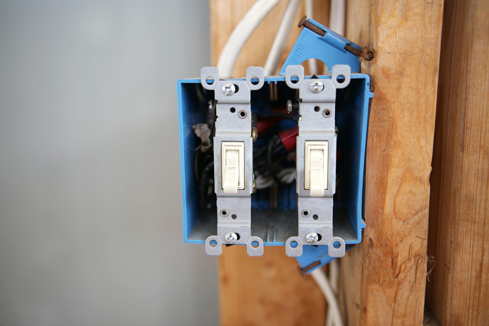 A two gang, 120 volt single pole electrical switch box installed on a wooden stud with wiring visible.  All logos removed.  Remaining text is generic. Horizontal with room for text per customer request.